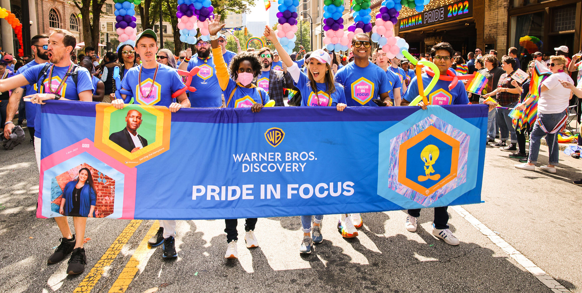 Photo of Warner Bros. Discovery employees carrying a banner reading "Pride in Focus" at the 2022 Atlanta Pride Parade